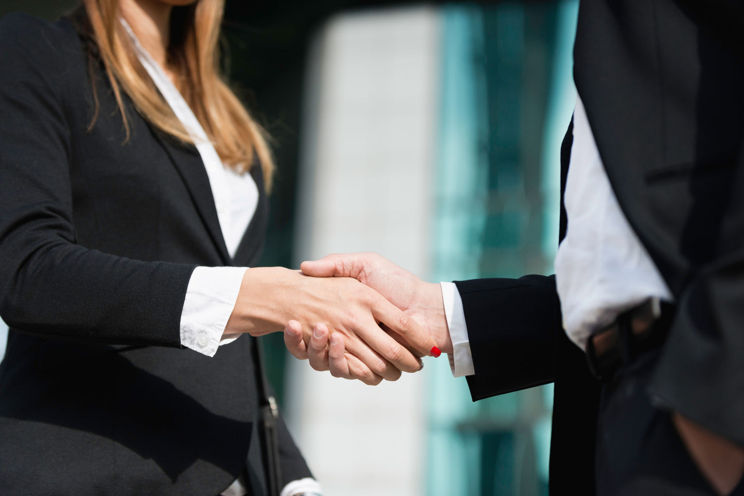 Two businesspeople shaking hands with a blurred background
